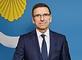 Prezydent Olsztyna na tle flagi miasta