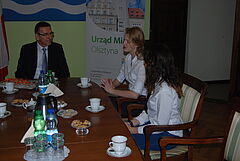 Spotkanie uczennic z prezydentem Olsztyna. Od lewej siedzą przy stole Piotr Grzymowicz, Anna Zielnik i Martyna Pawlak