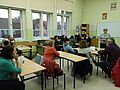 Uczestnicy spotkania siedzą w ławkach